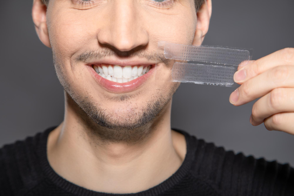 man-with-whitening-stripes-his-face-smiling-happy-with-fresh-dental-teeth